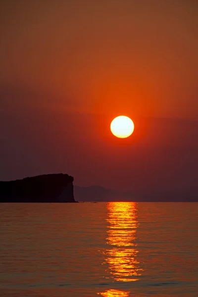 Σιλουέτα Ενός Γκρεμού Φόντο Έναν Πορτοκαλί Ηλιοβασίλεμα Κύματα Της Θάλασσας — Φωτογραφία Αρχείου