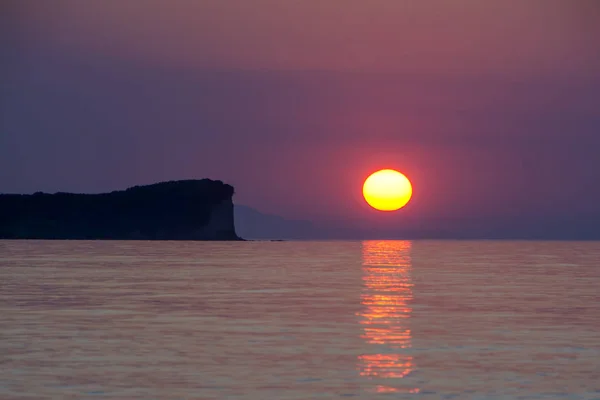 オレンジ色の夕日の背景に崖のシルエット 海の波は 岩を中断します コルフ島 ギリシャの夕日 — ストック写真