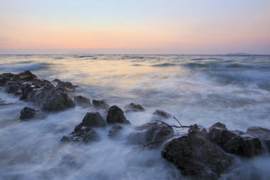 Uzun pozlama Denizi ve kayalar, denize, sahilde günbatımı sırasında dalga günbatımı. Güzel alacakaranlık arka plan. Ünlü Logas beach cliff Corfu Island, Yunanistan