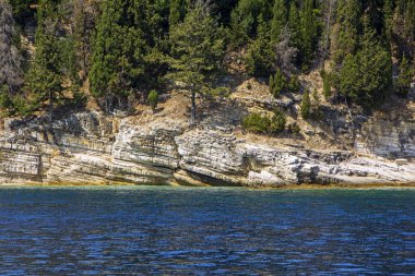 Güzel küçük bir ada: Korfu, Yunanistan kırık taş cliff ve mount üzerinde yeşil tropikal ağaçlar ile. Turkuaz rengi deniz kontrast beyaz taşlarla