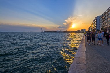 Thessaloniki, Yunanistan - 06 Temmuz 2018: şehir sahil güzel günbatımı arka plan üzerinde yürüyen insanlar