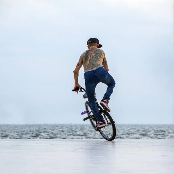 希腊塞萨洛尼基 2018年7月6日 一名运动自行车运动员在有海景的城市地区做自行车上的极端把戏 Bmx 骑自行车的人在自行车上制作复杂的技巧 — 图库照片