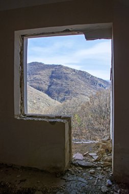 Boş oda ile terk edilmiş evde ve doğa manzaralı ve dağlar arka plan üzerinde kırık pencere kıyamet iç. Yıkım ve savaş kavramı