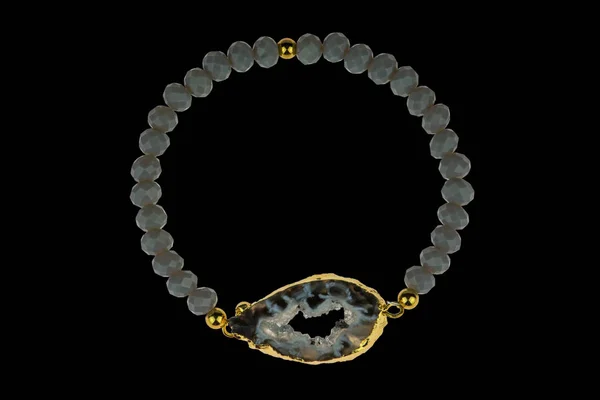 Luxury expensive jewelry with grey amethyst abstract gemstone in gold isolated on black background. Elegance bracelet with natural stone