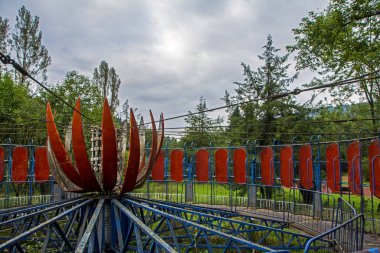 Terk edilmiş bir şehirde yalnız, eski atlıkarınca kıyamet görünümünü. Renkli, harap ve büyümüş atlıkarınca yeşil bir park ile dramatik sahne. Dehumanization kavramı