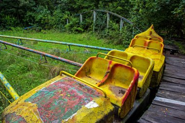 Terk edilmiş bir şehirde yalnız, eski atlıkarınca kıyamet görünümünü. Renkli, harap ve büyümüş atlıkarınca yeşil bir park ile dramatik sahne. Dehumanization kavramı