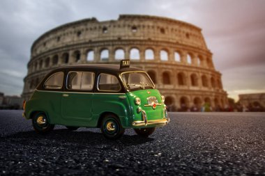 Küçük eski klasik İtalyan yeşil araba Colosseum ile Roma Caddesi üzerinde arka plan bulanık güzel günbatımı ışığında, İtalya yaktı. Küçük alan derinliği