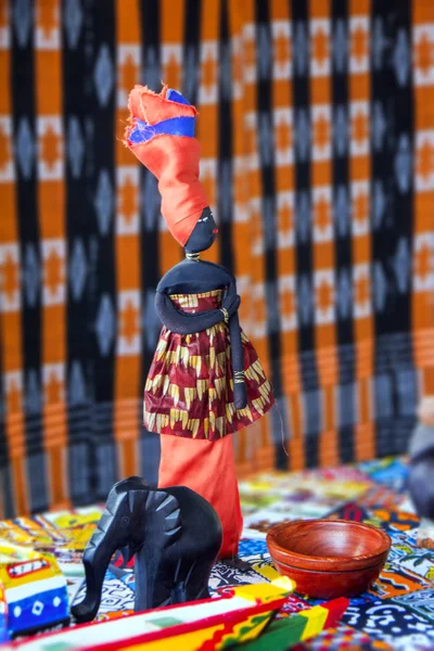 五颜六色的非洲娃娃在国家服装与黑色木象在模糊的背景地毯与传统模式 — 图库照片