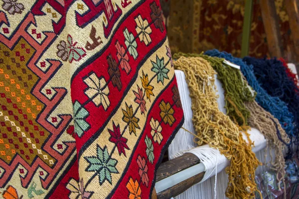 Colorful traditional Armenian carpets with different colored woolen thick fibers for making carpets on the weaving machine for carpet as a background