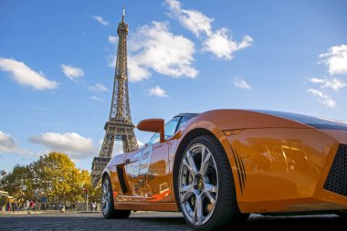 Paris, Fransa - 13 Kasım 2018: Düşük açılı görünümü üzerinde turuncu Lamborghini Gallardo hypercar Eyfel Kulesi ile arka plan bulanık