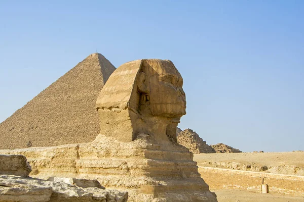 Egyptian sphinx with pyramids and blue sky on background. Cairo. Giza. Egypt. Travel background. Architectural monument. The tombs of the pharaohs. Vacation holidays background wallpaper