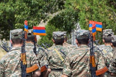 Ermeni askerleri otomatik tüfek ve süngü Bıçaklar bağlı Ermenistan bayrakları ile yürüyen bir takım. Arka plan bulanık, Ermenistan üzerinde yeşil ağaçlar ile arkadan görünüm