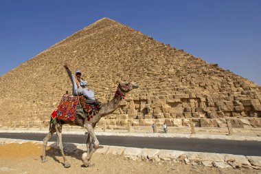 Giza, Mısır - 30 Ekim 2018: Bedevi çöl büyük antik Giza Piramidi yakınında, deve üzerinde