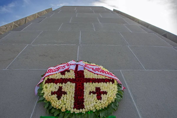 A wreath with pattern of the Georgian flag at the Armenian Genocide memorial in Tsitsernakaberd. Translation: From Georgian Government. Low angle view