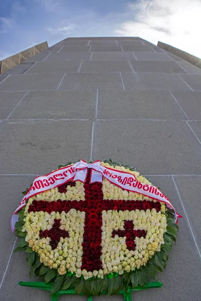 A wreath with pattern of the Georgian flag at the Armenian Genocide memorial in Tsitsernakaberd. Translation: From Georgian Government. Low angle view