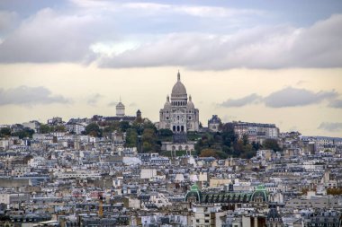 Paris Notre Dame ve Kutsal Kalp Bazilikası'nın güzel manzarasına günbatımı bulutlu gökyüzü altında