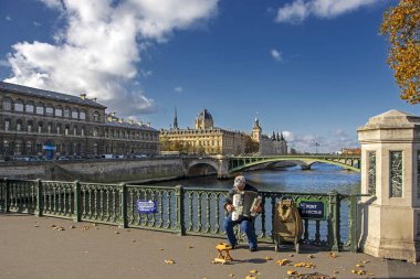 Paris, Fransa - 13 Kasım 2018: Arka planda Arcole köprüsünde (Pont d'Arcole) Seine nehri ve Adliye (Greffe du Tribunal de commerce de Paris) ile akordeon çalan sokak müzisyeni