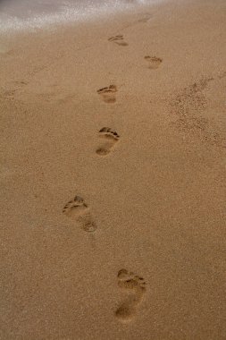 Plajın ıslak kumüzerinde çıplak ayak izleri