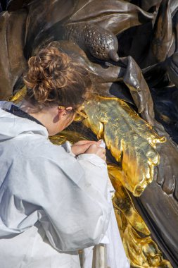  An unrecognizable restorer who is working on bronze sculptures on the Alexander III Bridge across Seine river in Paris, France clipart