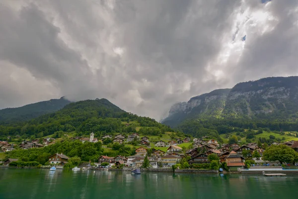 ドラマチックな曇り空の下 観光船からトゥーン ショア湖畔に位置するスイスアルプスの Merligen スイスの美しい景色 — ストック写真