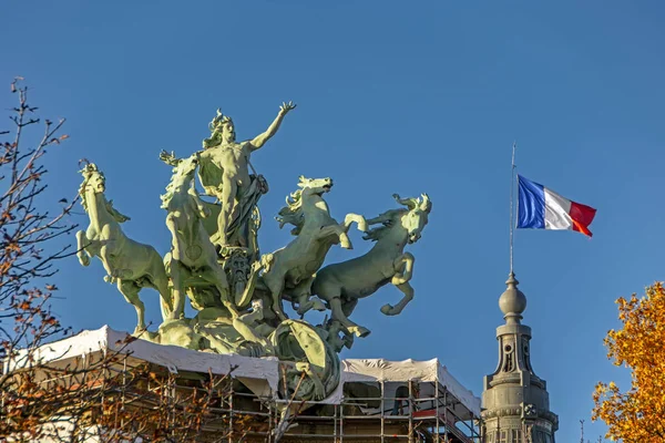 美しい有名なモニュメントクアドリガ像とフランスのパリの青空に対するフランスの旗 宮殿の屋根から飛び降りる青空と緑の青銅の馬 イモータル デヴァンカント テンプス — ストック写真