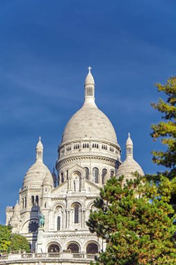 Sacre Coeur Bazilikası da Kutsal Kalp Bazilikası ve mavi gökyüzüne karşı yeşil ağaçlar olarak bilinen Montmartre paris, Fransa en yüksek 130 metre lik tepe bulunmaktadır
