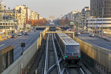 Paris, Fransa - 17 Kasım 2018: Arc de Triomphe'ye doğru hareket eden metro treninin gün batımı ışığıyla aydınlatılmış arka planda perspektif görünümü