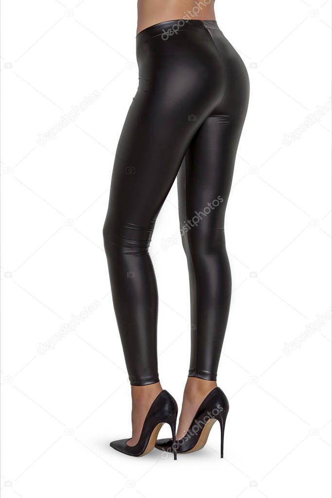 Beautiful slim female legs in black leather leggings and high heel shoes isolated on white background. Concept of stylish clothes, beauty, fashion and slim legs