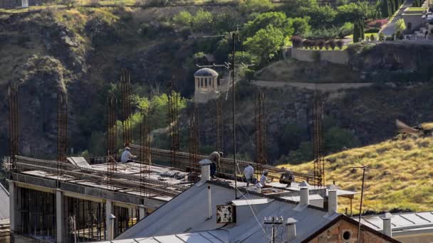 労働者は建物の屋根に継手をマウントします コンクリート注入の準備の前に 補強の建設に関する作業プロセス 鳥は空を飛ぶ 背景に美しい渓谷 アルメニアのエレバン — ストック動画