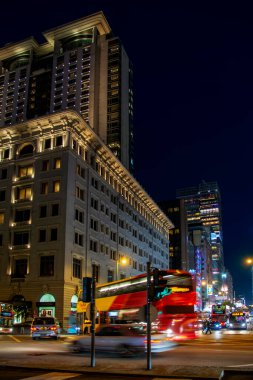 Hong Kong, Çin - 20 Şubat 2014: Hong Kong 'daki gece sokak trafiğinin soyut görüntüsü. Bulanık ulaşım ışıkları olan gökdelen binaları
