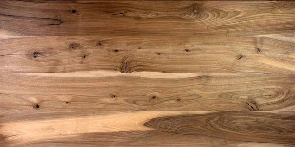Masa ahşap yüzeyi doğal cevizden. Düğümleri ve güçlü çizgileri olan zengin ahşap desenli arka plan. Boşluğu kopyala