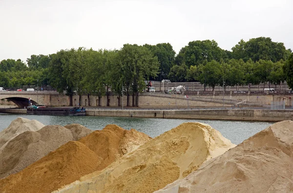 Sand stored on a bank of the Seine in Paris. Raw material in wait. (France)