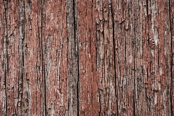 Старая пилинговая краска на деревянной поверхности. фон стены, окрашенной красной краской — стоковое фото