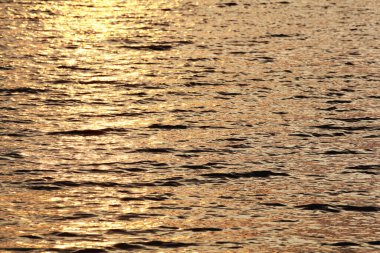 Güneş ışınlarının havadaki güzel arkaplanı bir göle yansıyor. Suyun üzerinde sonbahar sineması. Huzurlu güneş ışınları büyük bir gölün dalgalarında yansıyor. Hava fotoğrafçılığı. Boşluğu kopyala