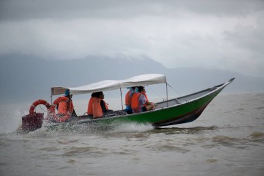 Kampung Bako, Malezya - Circa Januar, 2015: Turist nehir Bako Kampung Bako, Malezya içinde bir teknede Kılavuzu. Adam bir kıyıdan insanlara günde birden çok kez taşımaktadır.