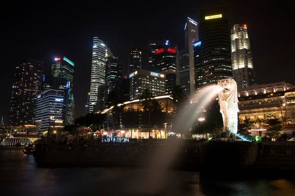 新加坡 Circa 2015 夜景的鱼尾狮喷泉和新加坡天际线 鱼尾鱼是一种神话中的生物 有狮子的头和鱼的身体 被视为新加坡的象征 — 图库照片