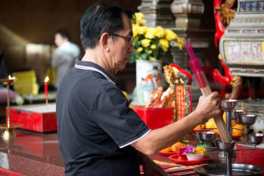 Penang, Malezya Ocak 2015 Malezyalı adam Penang, Malezya, Georgetown 'daki Kek Lok Si tapınağında tütsü çubukları yakıyor.