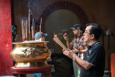 Penang, Malezya Ocak 2015 Malezyalı adam Penang, Malezya, Georgetown 'daki Kek Lok Si tapınağında tütsü çubukları yakıyor.