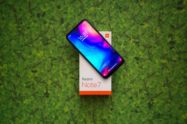 Braislava, Slovakya, 8 Nisan 2018: Xiaomi Redmi Note 7 akıllı telefon yeşil yaprakları arka plan