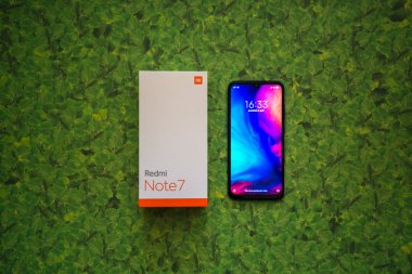 Braislava, Slovakya, 8 Nisan 2018: Xiaomi Redmi Note 7 akıllı telefon yeşil yaprakları arka plan