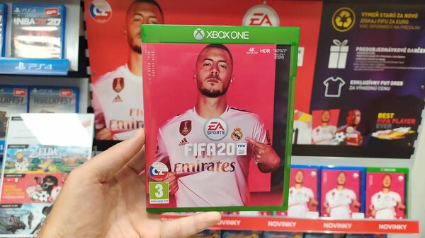 Bratislava, Slovakia, october 2, 2017: Man holding NHL 2020 videogame on Microsoft XBOX One console in store