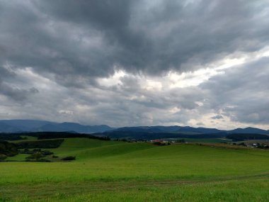 Yeşil ağaçlı ve fırtınalı gökyüzü