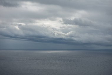 Bulutlardaki boşluktan boş denizi aydınlatan güneş