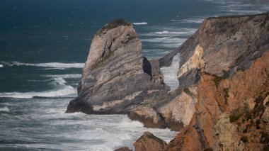 Denizde dramatik dalgalar ile çıplak kayalıkların yüksek açı görünümü
