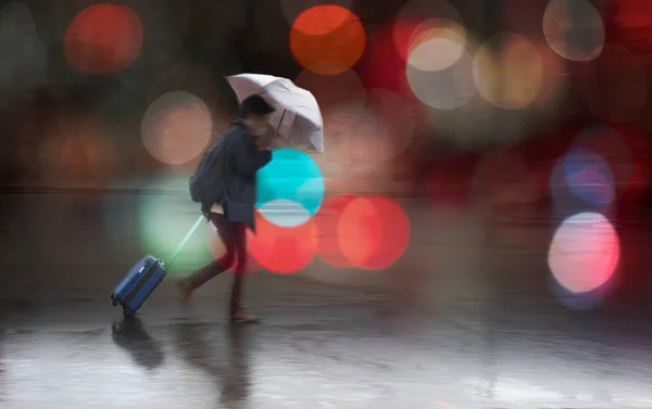 穿着雨衣 带着雨伞的年轻人背着小包走在雨中 — 图库照片