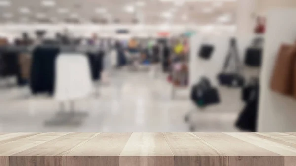 Boş ahşap masa ve bulanık giyim mağazası