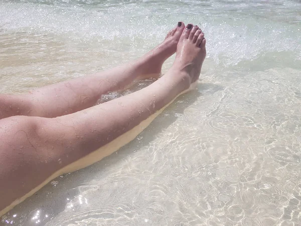 Kadının bacakları berrak suda