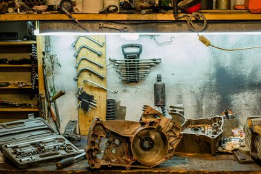 Garajdaki masaüstünde motosiklet parçaları ve araçlar