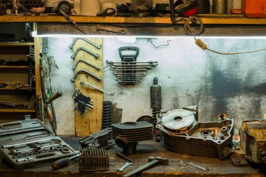 Garajdaki masaüstünde motosiklet parçaları ve araçlar