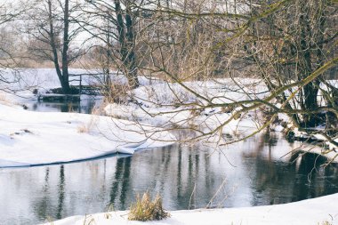 Ahşap, güneşli gün kışın nehirde